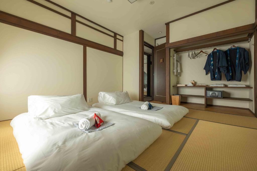 a bedroom with two beds with towels on them at Himecho@Yasushi in Nozawa Onsen