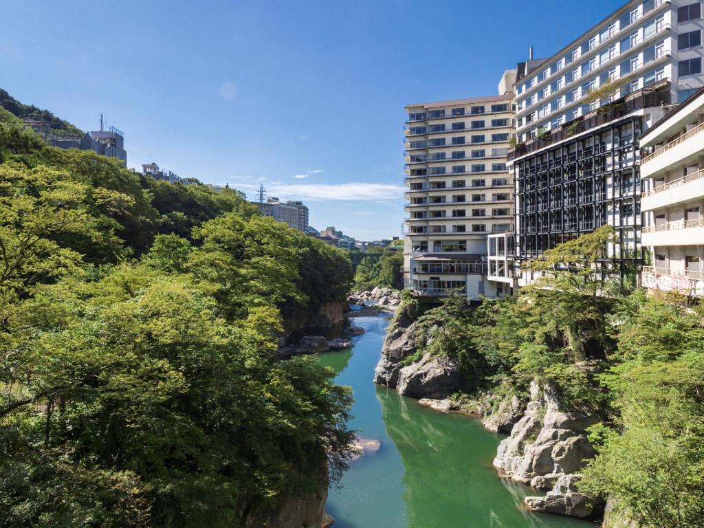 a river with buildings on the side of a mountain at Kinugawa Plaza Hotel in Nikko