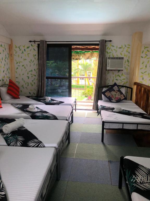 Irosin的住宿－Vi-Da Guest Resort，带四张床和窗户的客房