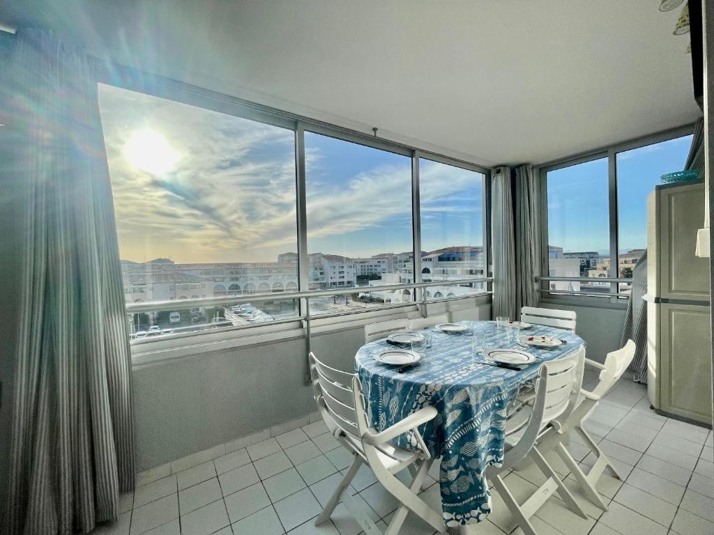 セットにあるAppartement Sète, 2 pièces, 6 personnes - FR-1-338-168のダイニングルーム(テーブル、椅子付)、大きな窓が備わります。