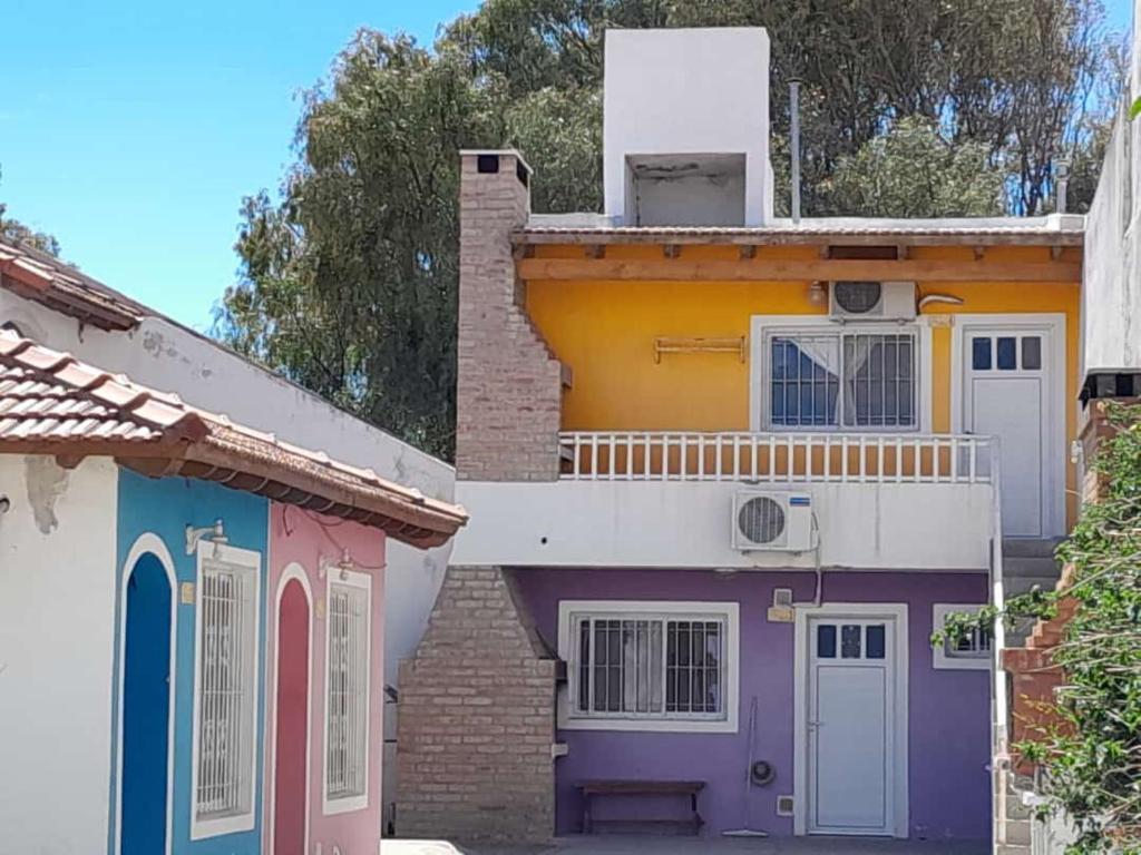 two houses with colorful doors in front of them at Departamentos Tere in Las Grutas