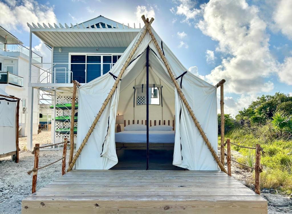 1 cama en una tienda frente a una casa en Beachfront Glamping, en San Pedro