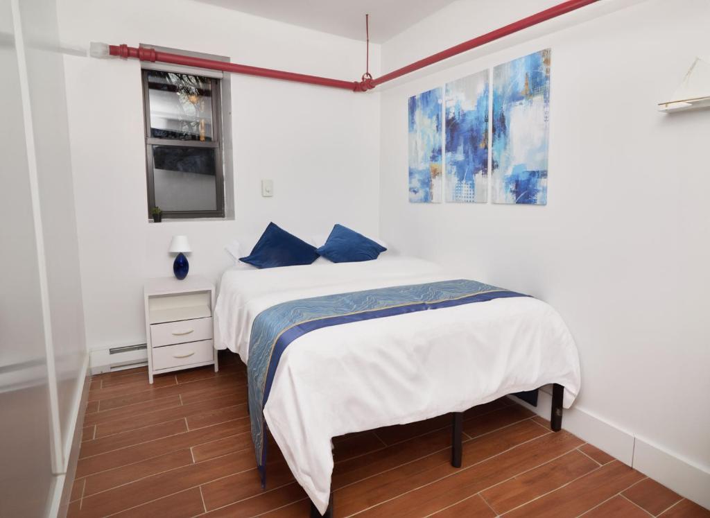 a bedroom with a bed with blue pillows at Comfy Guest House in Hell's Kitchen in New York