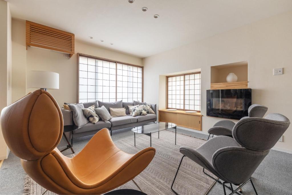 a living room with a couch and chairs at Kawazen in Nozawa Onsen