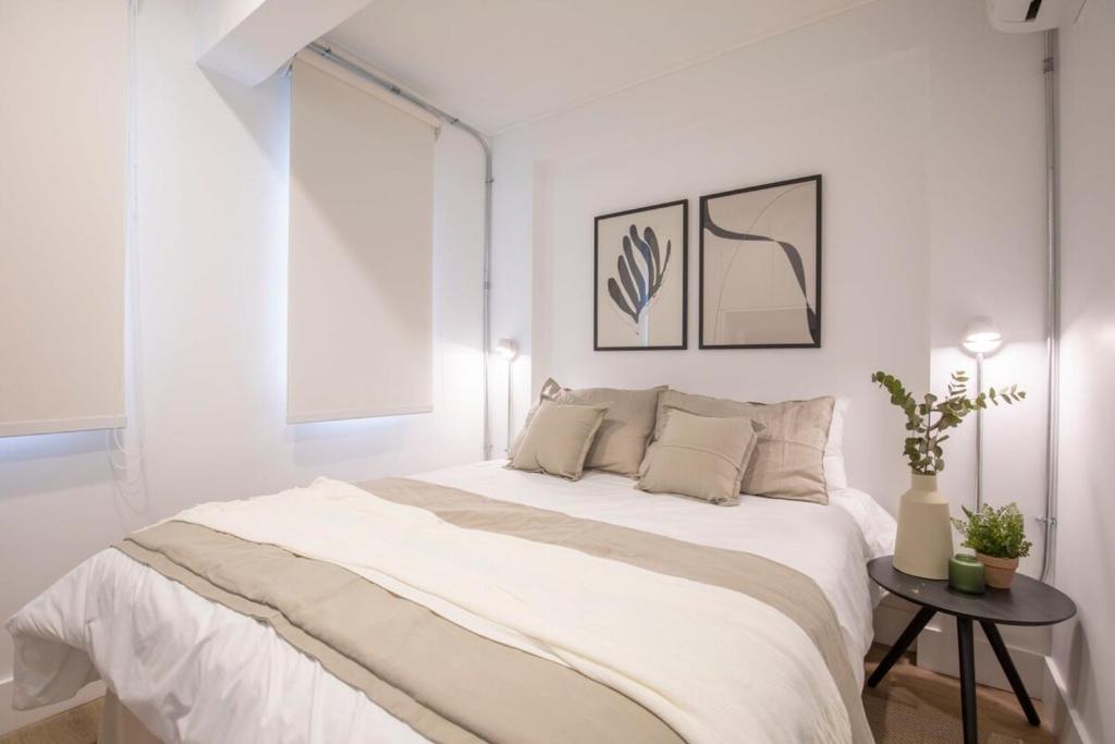 een witte slaapkamer met een groot bed en een tafel bij Acogedor y luminoso Studio en Icónico Barrio in Santiago