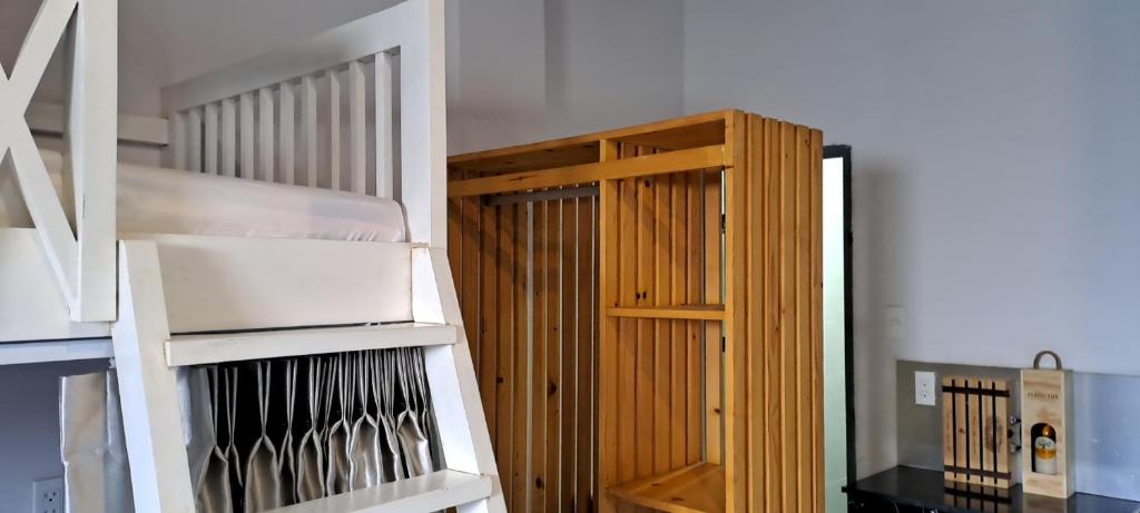 a wooden book shelf next to a stair case at Kidona's House in Da Nang