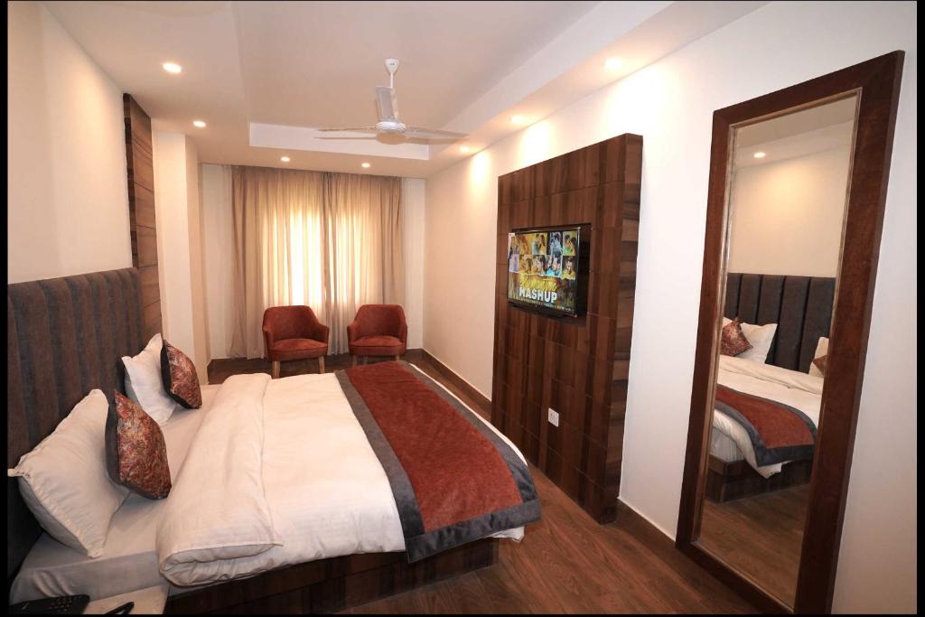 a hotel room with a bed and a mirror at Hotel Aaria in Mussoorie