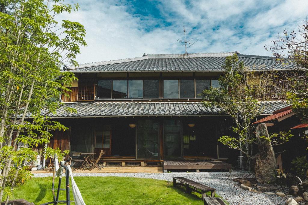 ein Haus mit Glastüren und einem Hof in der Unterkunft Masukichi 古民家宿ますきち 駐車場無料 in Seto