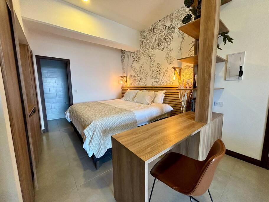 una camera con letto e scrivania con sedia di Tropical Apartment in the city a Guatemala