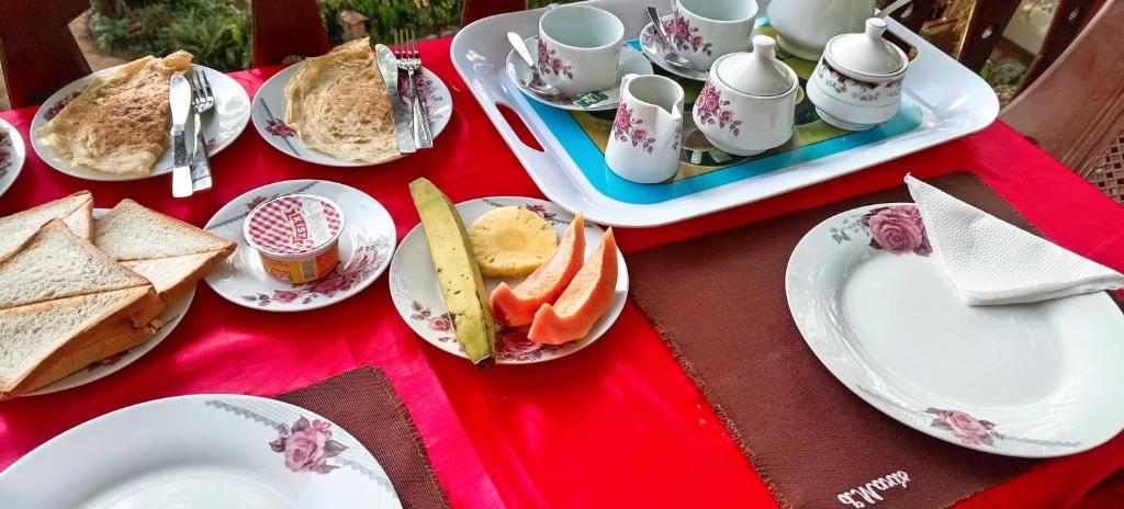 einen roten Tisch mit Teller mit Sandwiches und Tassen in der Unterkunft Ella Shali's home in Ella