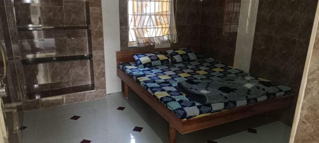 a small bedroom with a bed and a shower at Om Bungalow in Dwarka