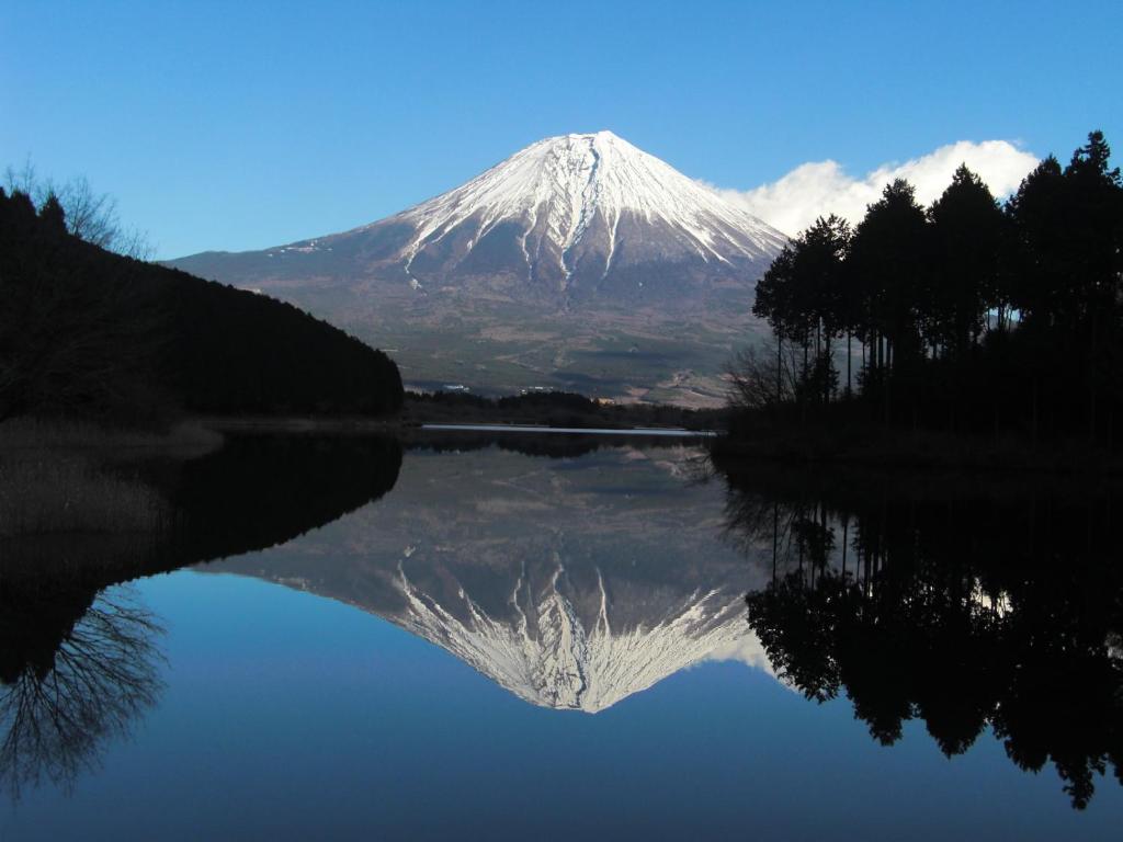 una montaña con su reflejo en un cuerpo de agua en Kyukamura Fuji en Fujinomiya