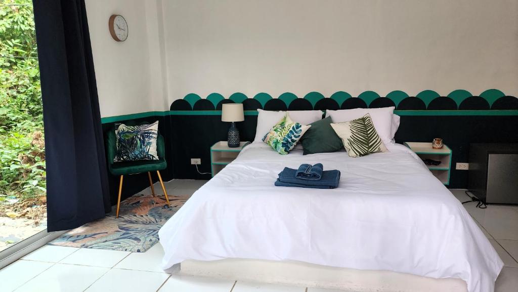 a bedroom with a white bed with a green headboard at Easy Life Koh Chang in Ko Chang