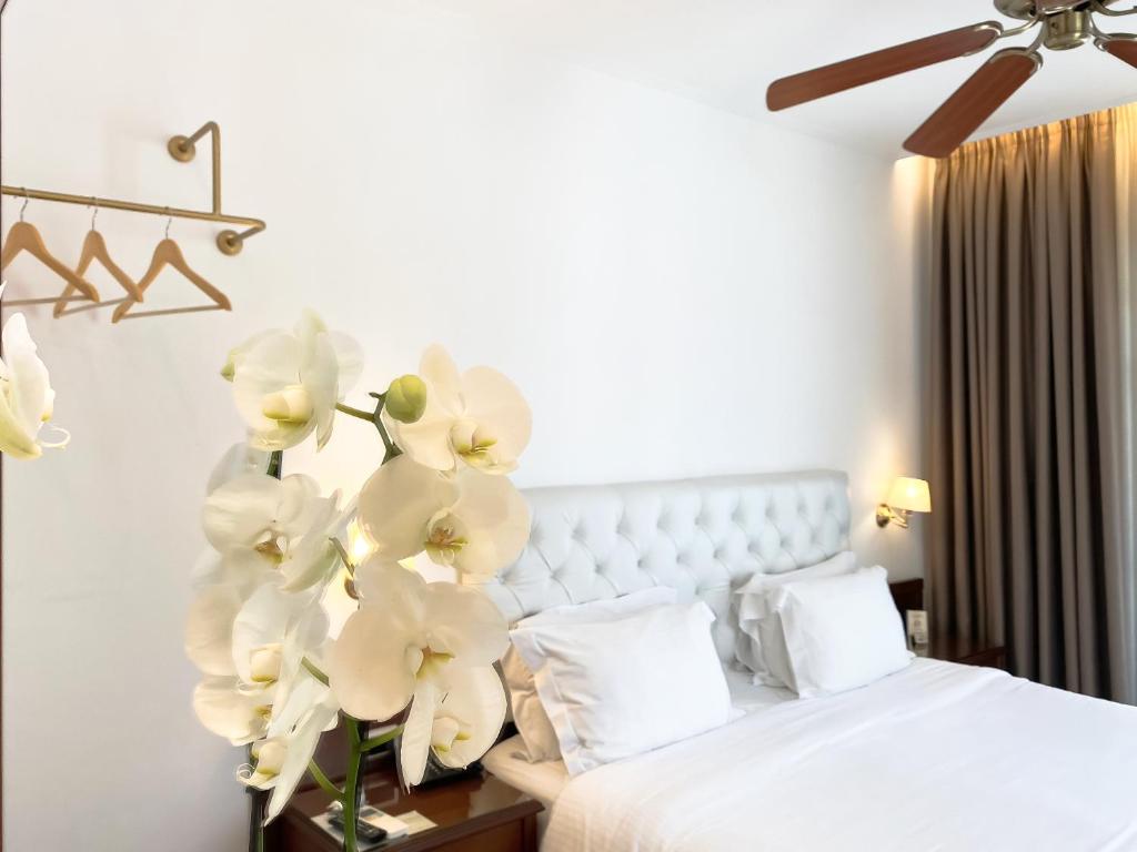 a bedroom with a bed with white flowers on a table at Armata Boutique Hotel in Spetses