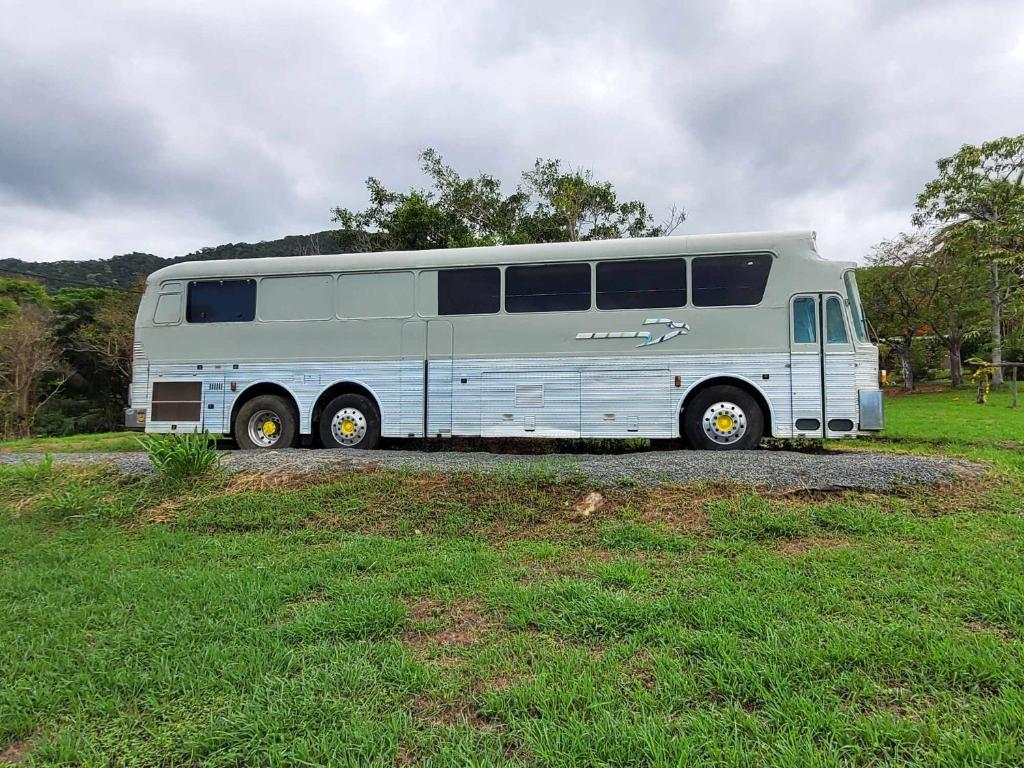 a silver bus parked in a grass field at Le Big Bus 