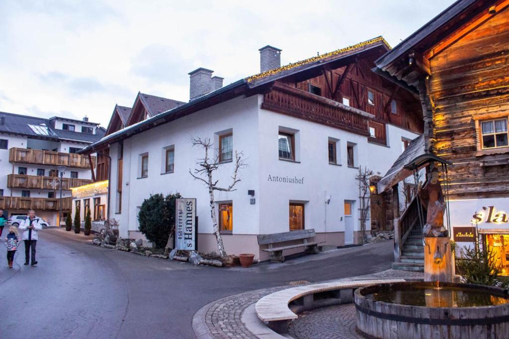 a building with a fountain in the middle of a street at Antoniushof - inklusive Super Sommer Card in Serfaus