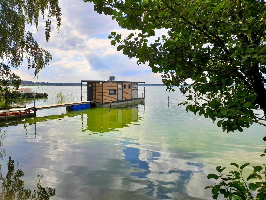 a house sitting on top of a body of water at Hausboot am See in Rieth