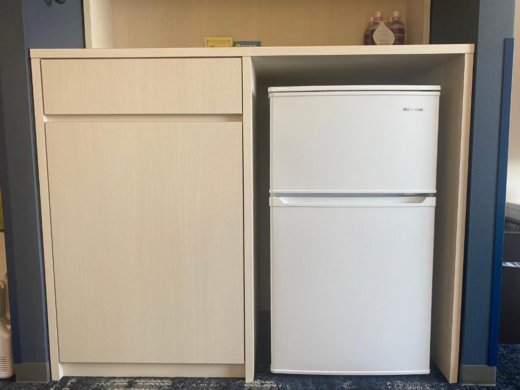 a refrigerator in a cabinet next to a freezer at Hotel Keihan Universal Tower in Osaka