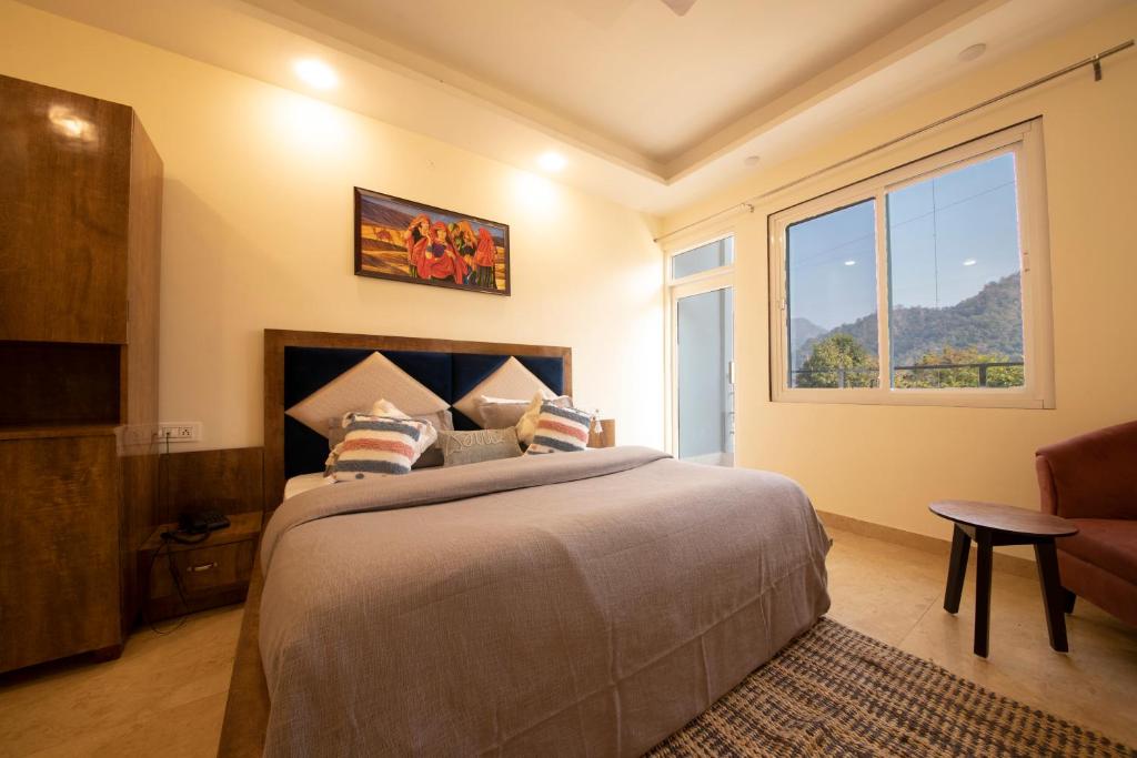 a bedroom with a large bed and a window at Perfect Stayz Hills in Rishīkesh