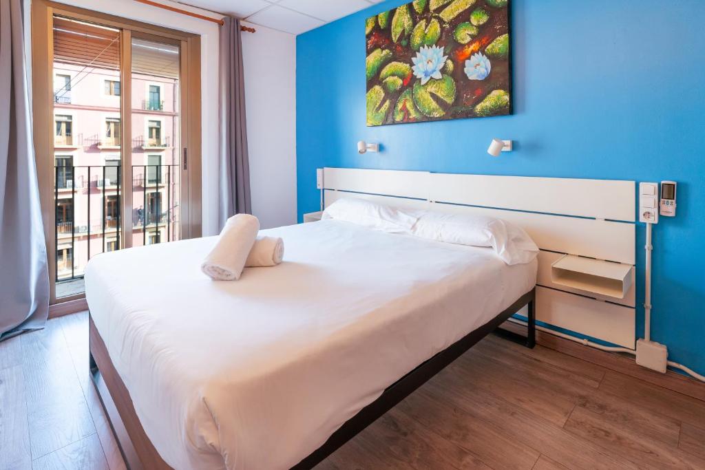 a bedroom with a large bed with a blue wall at Forum Tarragona in Tarragona