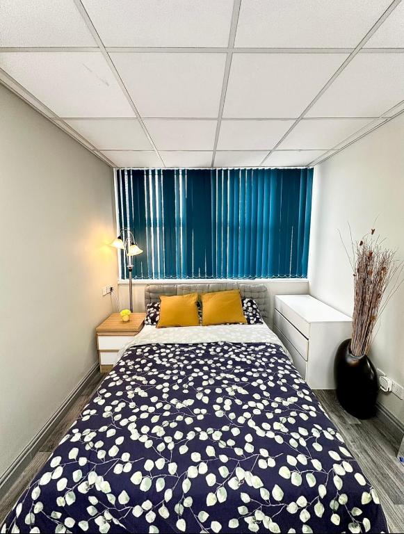 a bedroom with a large bed with yellow pillows at Papaya’s en-suite in Hoyland Nether