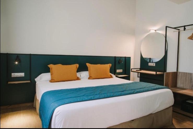 1 dormitorio con 1 cama grande y 2 almohadas de color naranja en Resort Inn Centrum en Szczecin