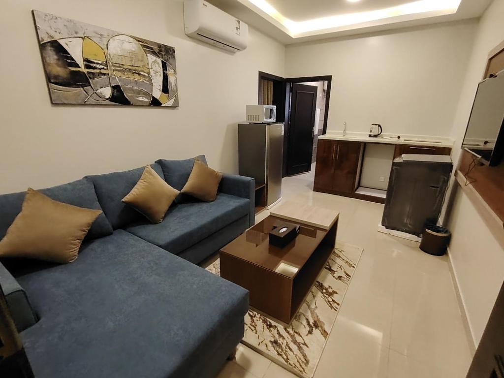 een woonkamer met een blauwe bank en een tafel bij دريم بارك العليا in Al Khobar