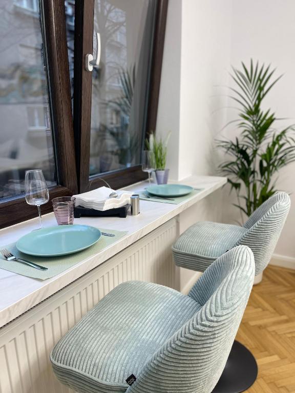 a restaurant counter with two chairs and plates and glasses at Style Central in Bucharest
