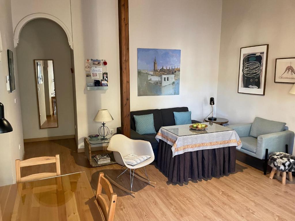 sala de estar con mesa y sofá en VIVIENDA SAN AGUSTÍN, en Sevilla