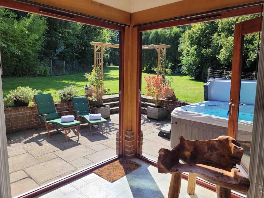 a screened in porch with a dog laying on a bench at Honeysuckle Cottage Annex with hot tub near Needham Market in Needham Market