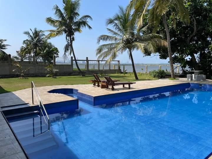 a swimming pool with two benches and a picnic table at Olivia Bungalow in Wattala
