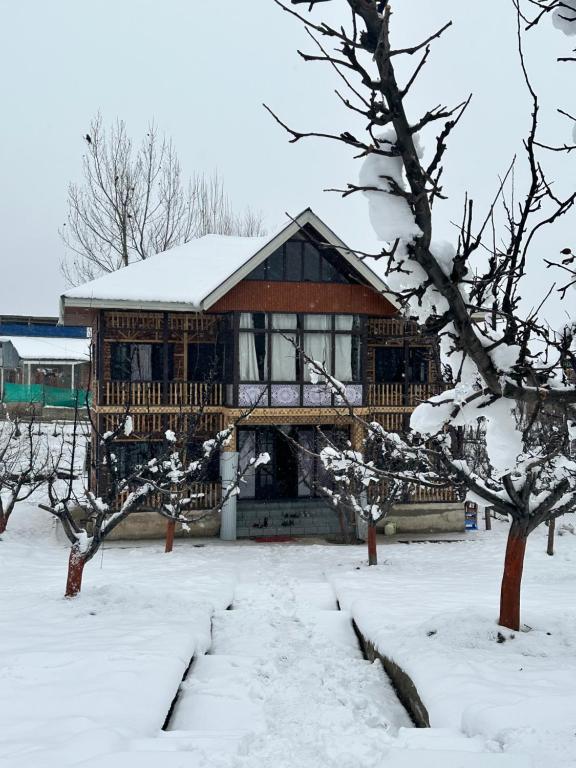 une grande maison en bois avec de la neige au-dessus dans l'établissement Hideaway Cottages "Home in Kashmir", à Gulmarg