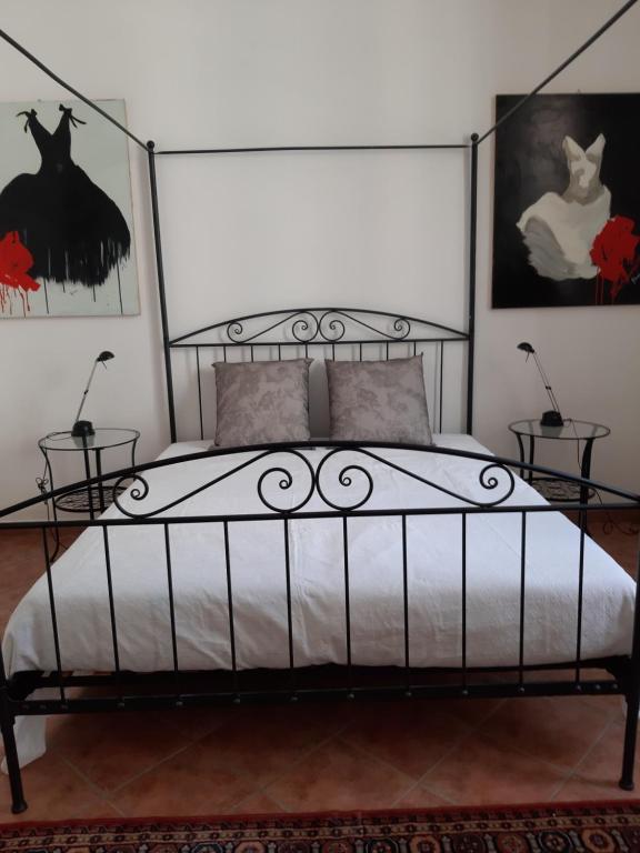 una camera da letto con un letto di metallo con due tavoli di MI12 ad Albenga