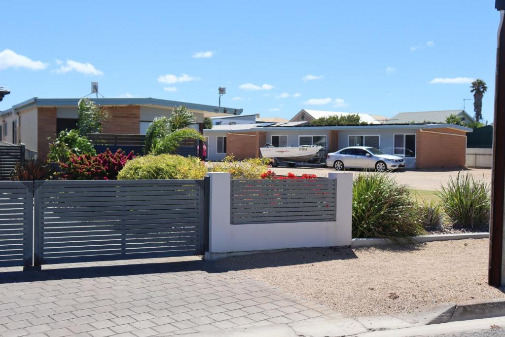 uma vedação em frente a um parque de estacionamento com casas em Edithburgh Foreshore Apartments em Edithburgh