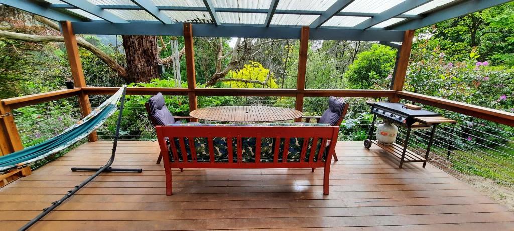 a deck with a hammock and a table and a piano at The Bower in Kalorama