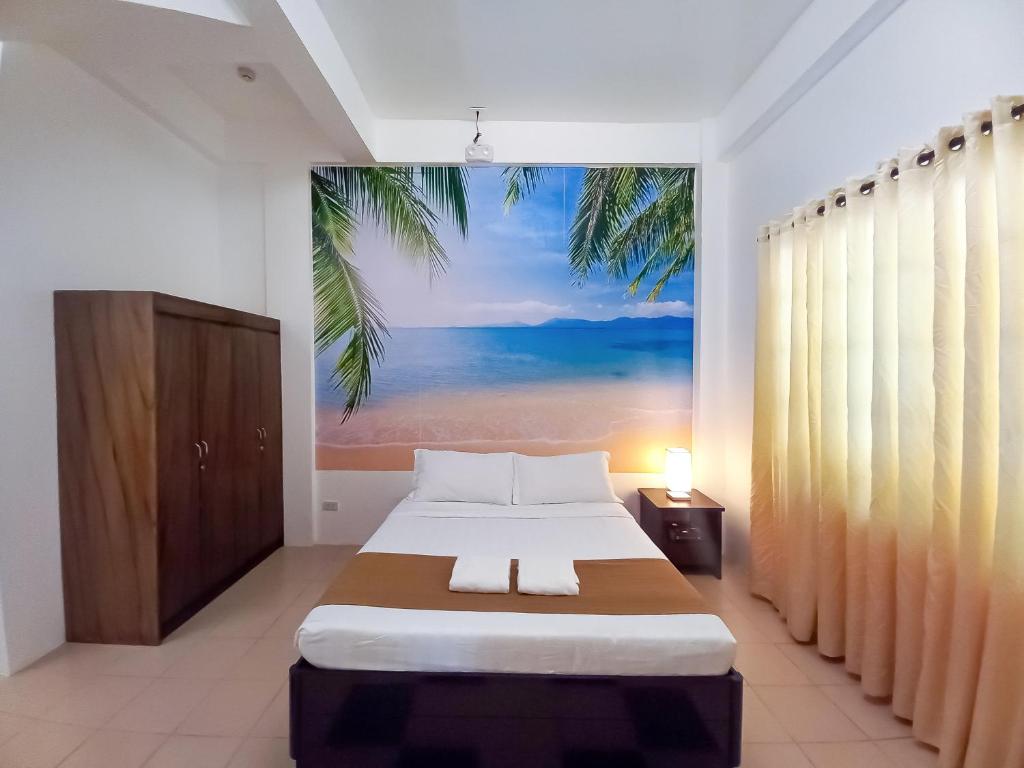 een slaapkamer met een bed met een schilderij aan de muur bij Castle Rock Apartelle in Boracay