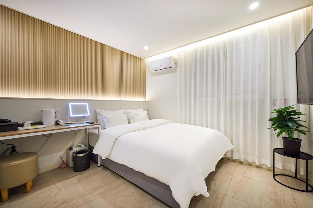 a bedroom with a bed and a desk with a computer at Urban Hotel 