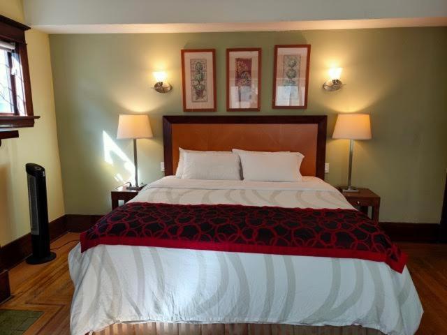 - une chambre avec un grand lit et deux lampes dans l'établissement Vancouver guest house, à Vancouver