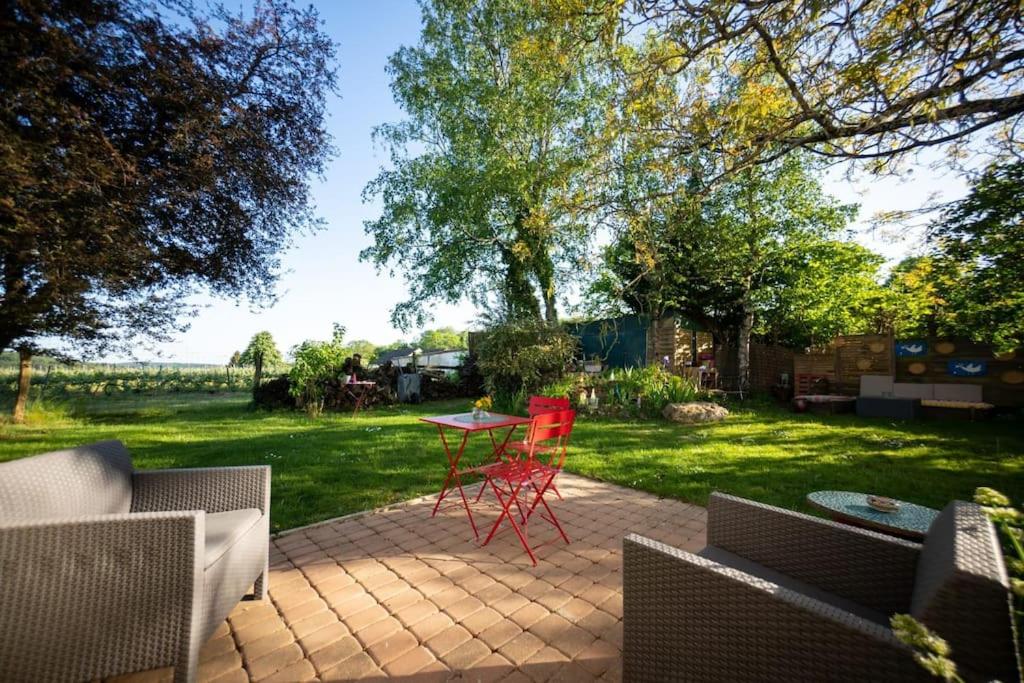 un patio avec une table et des chaises dans une cour dans l'établissement Horizon en Champagne, studio avec jardin et vue, à Germaine