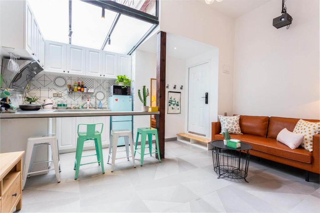 a living room with a couch and a kitchen at Shanghai Hills&XING 593 Homestay Mid Huaihai Rd Near Metro Line 1 North Zhongshan Rd in Shanghai