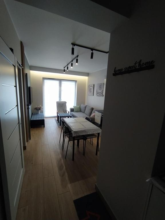 ein Wohnzimmer mit einem Tisch und einem Sofa in der Unterkunft Apartament Zacisze 3 modern in Częstochowa