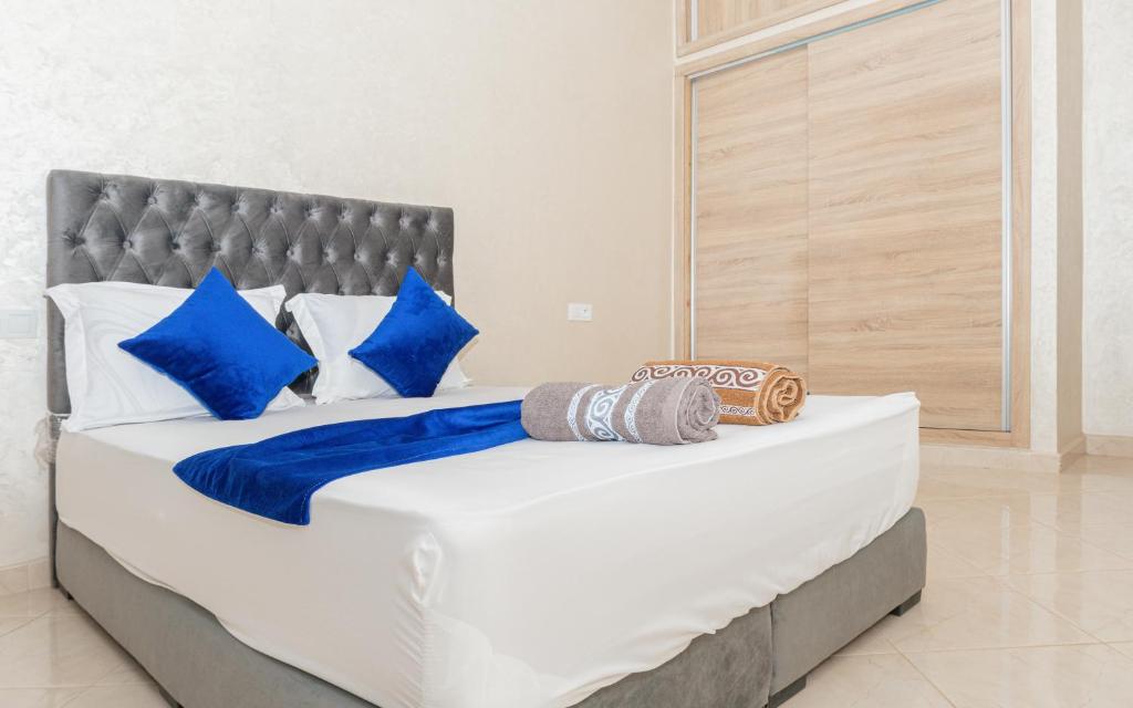 a large bed with blue and white pillows on it at Imsouane Wave Residences in Imsouane