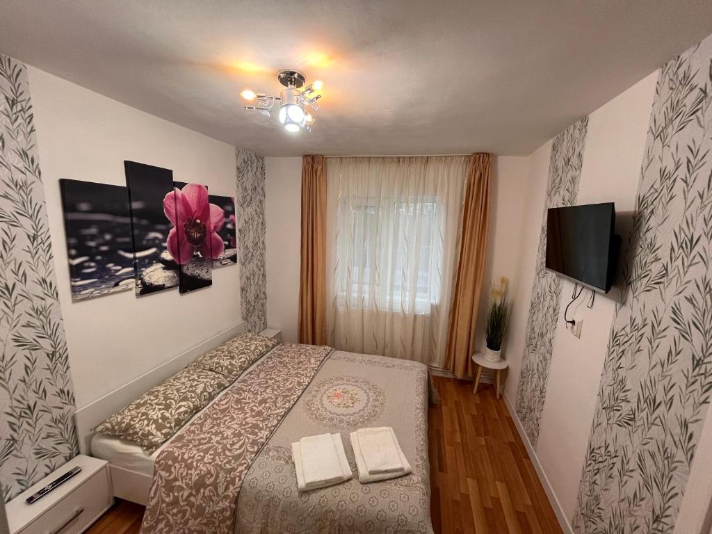 Dormitorio pequeño con cama y TV en Medeea en Zalău