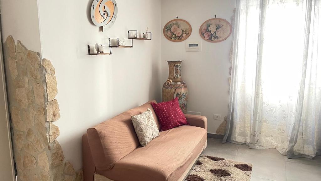 uma sala de estar com um sofá e um relógio na parede em La Maison2 em Mondragone