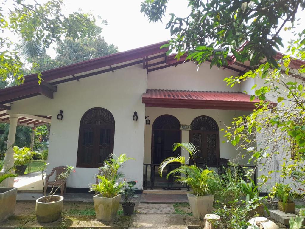 a small white house with a red roof at JANA HOUSE in Galle