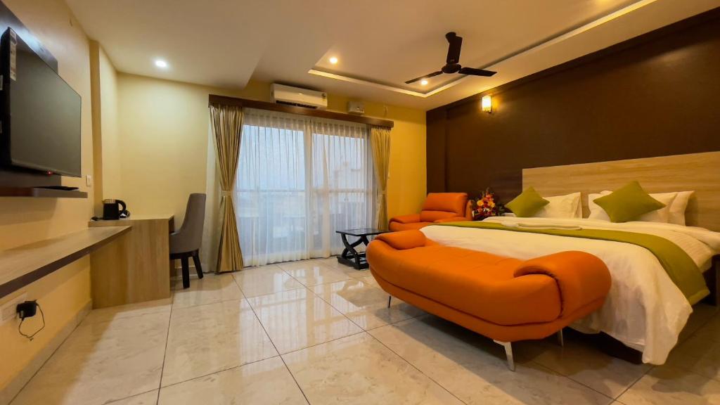 a bedroom with a large bed and a flat screen tv at Hotel Kinotree Yeshwanthpur in Bengaluru