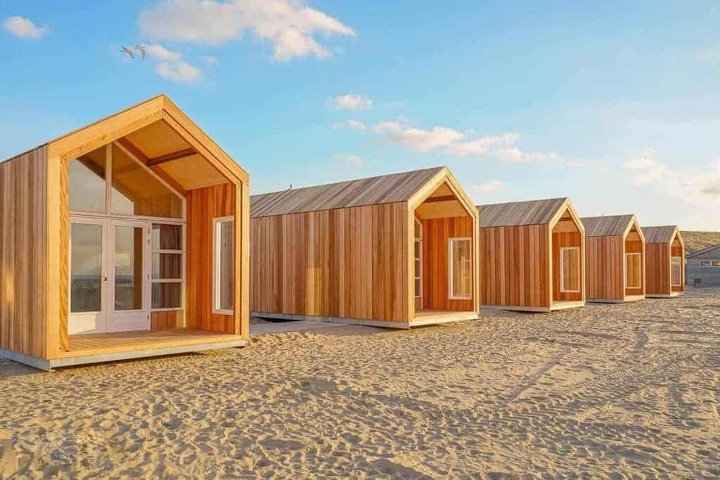 una fila de casas de madera sentadas en un campo en Sisters Beachbungalows, en Katwijk aan Zee