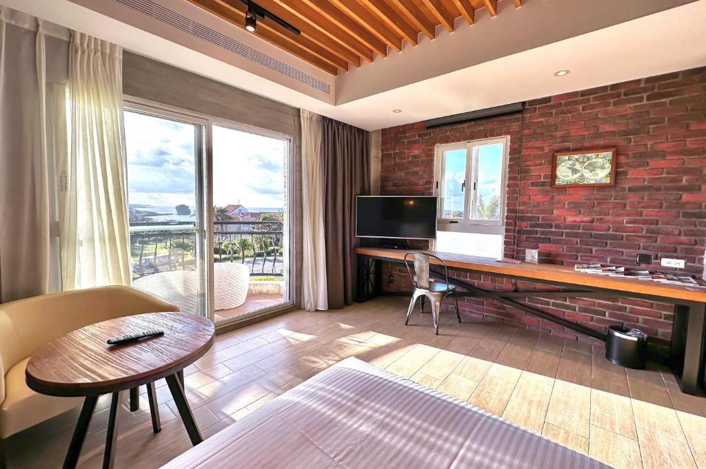 a living room with a desk and a brick wall at Kenting 4 Sisters Villa in Eluan