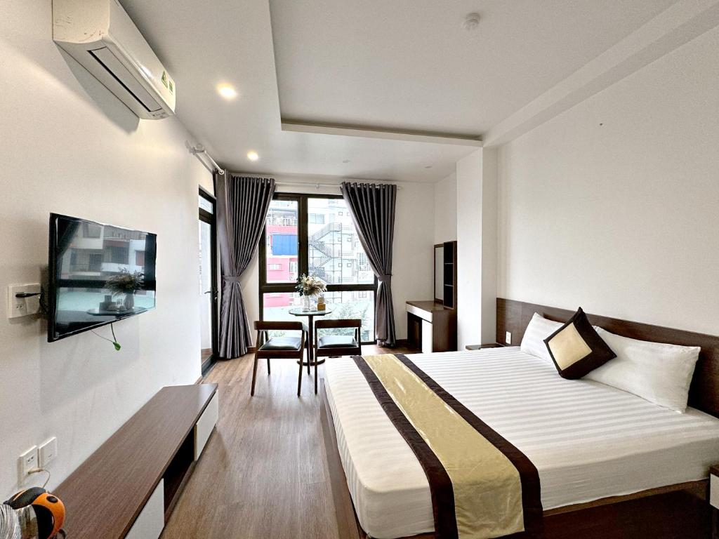 1 dormitorio con cama, mesa y TV en Au79 Hotel & Apartment, en Hai Phong