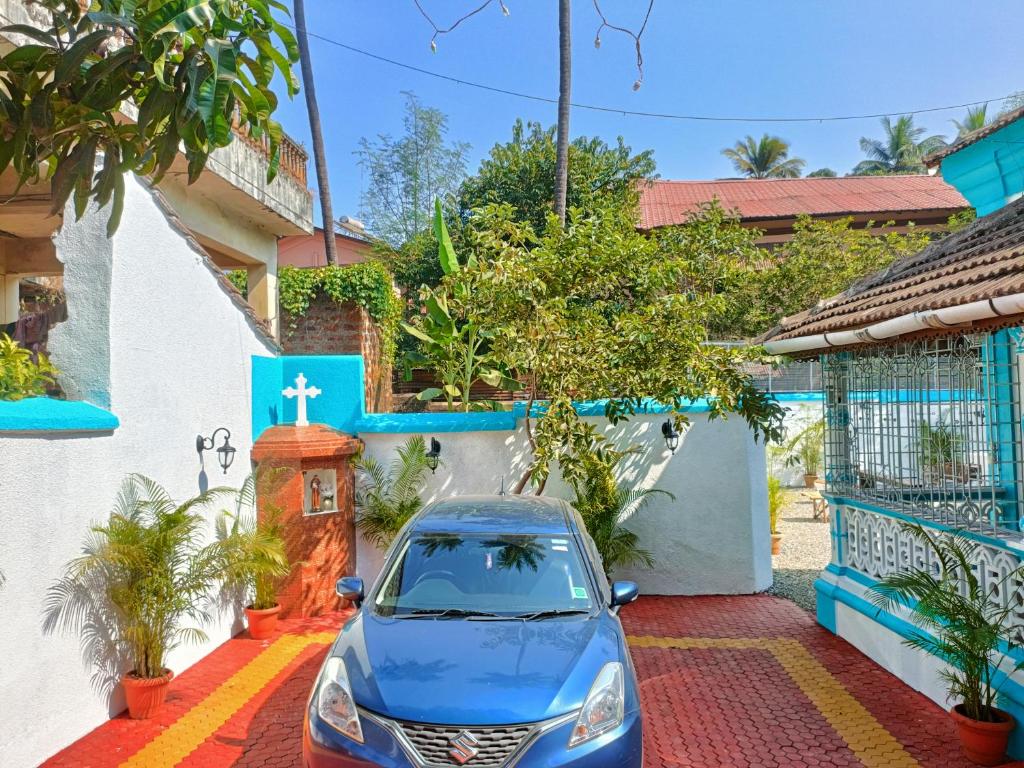 a blue car parked in front of a house at Mendes in Mapusa